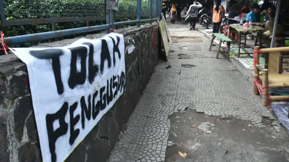 Tolak Pembongkaran Tanpa Musyawarah, PKL Depan Unisba Minta Pemerintah Duduk Bersama Spanduk bertuliskan tolak penggusuran terpasang di depan kantin deret di depan kampus Universitas Islam Bandun