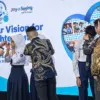 Direktur PT Rohto Laboratories Indonesia Mukdaya Massidy (kiri) saat menyerahkan kacamata gratis kepada pelaja