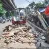 Operator menggunakan alat berat membongkar drainase di bekas lahan pembongkaran PKL mandiri di Kiaracondong, K