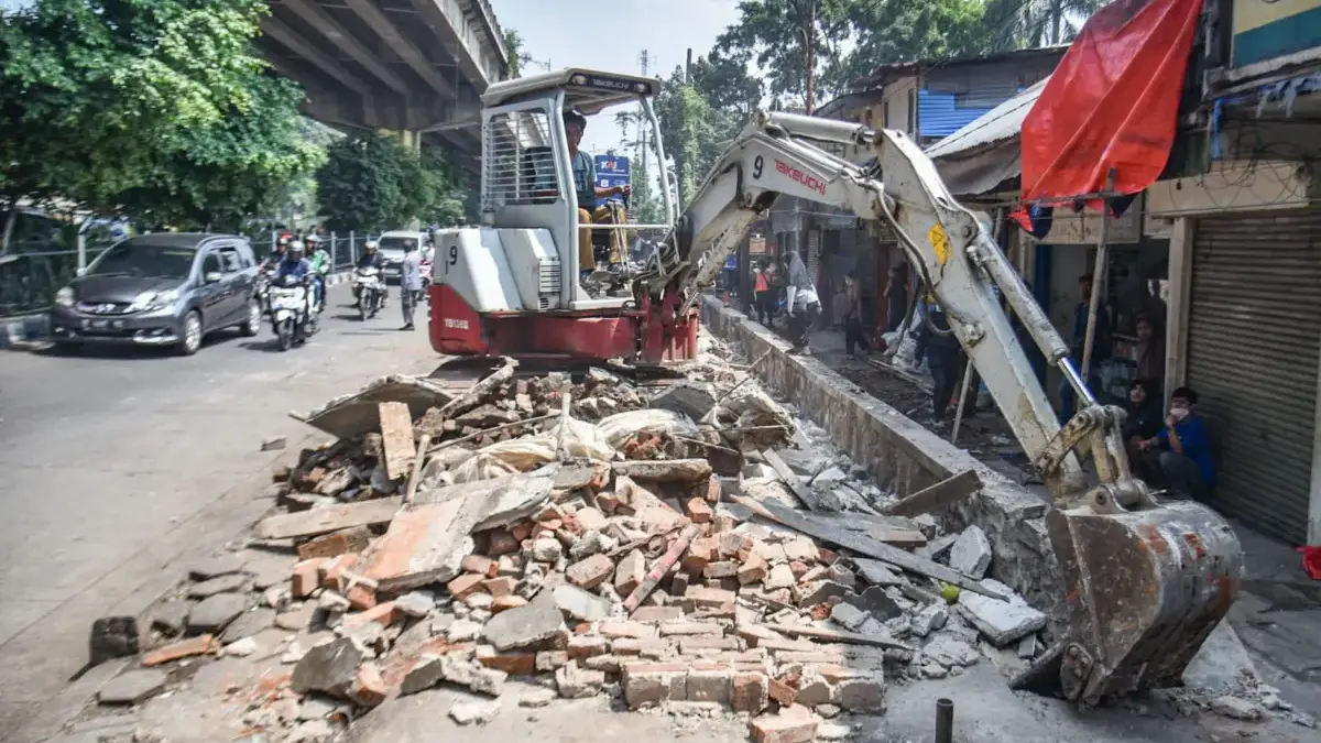 Operator menggunakan alat berat membongkar drainase di bekas lahan pembongkaran PKL mandiri di Kiaracondong, K