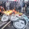 Pengunjuk rasa membakar poster Presiden Prabowo saat aksi peringatan pemerintahan dua tahun Prabowo-Gibran di