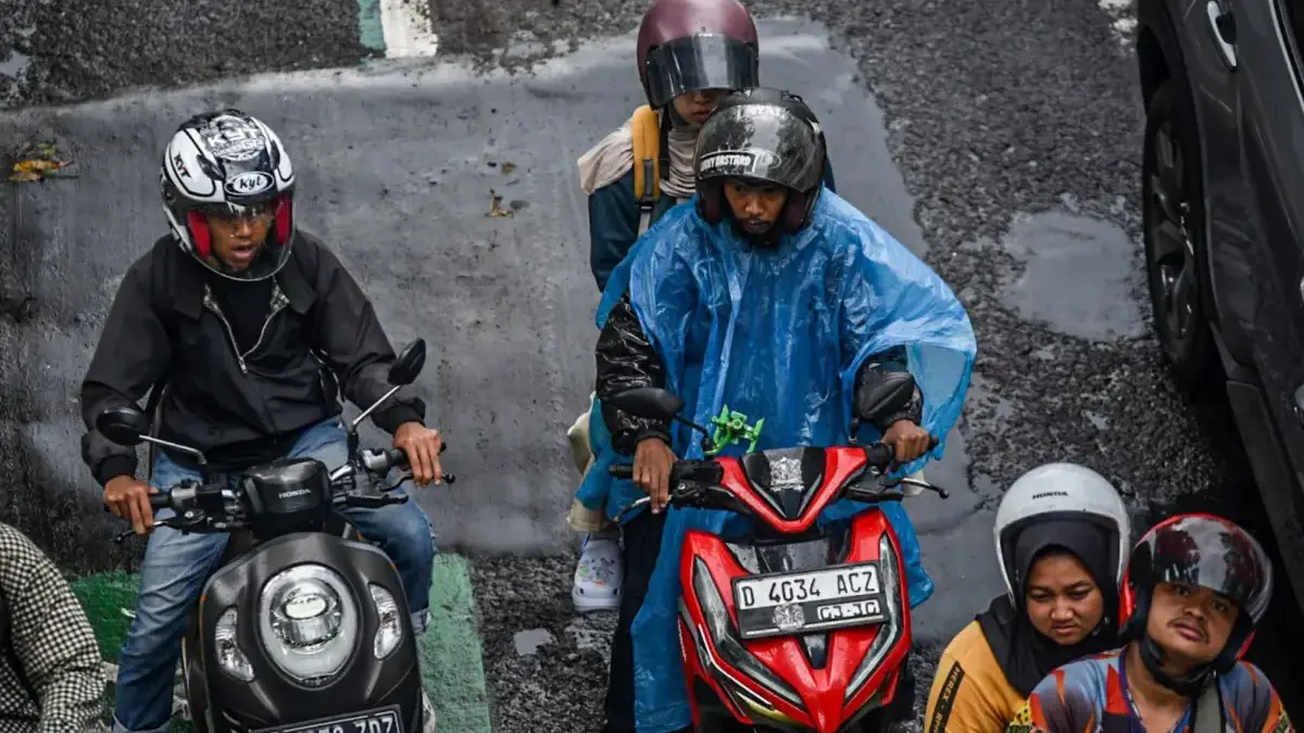 Pengendara sepeda motor menggunakan jas hujan saat di Jalan Merdeka, Kota Bandung, Kamis (1/10/2026). Foto: Di