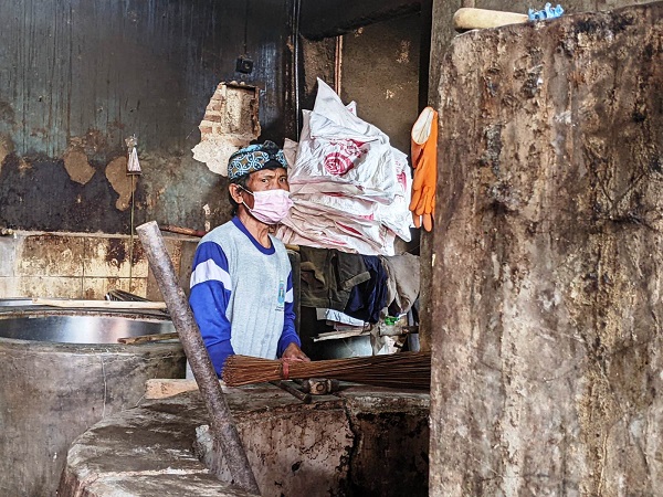 TAK PRODUKSI: Pengusaha tahu Karawang, Sidik Rillah membersihkan tungku atau tempat memasak pakai kayu bakar. AEP SAEPULOH/PASUNDAN EKSPRES