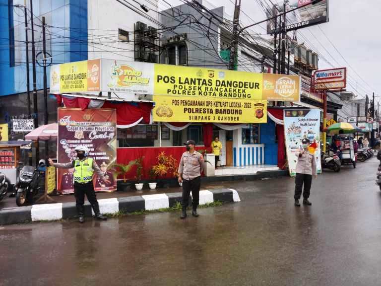 ATUR LALU LINTAS-Anggota Polsek Rancaekek saat mengamankan area sekaligus mengatur lalu lintas di Pos Pam Ketupat Lodaya Rancaekek. JABAR EKSPRES