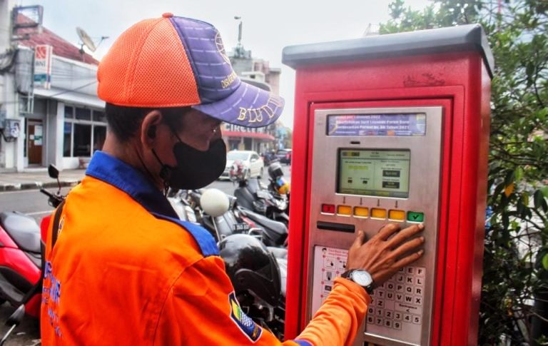 MESIN PARKIR: Seorang petugas tengah mengoperasikan mesin parkir di Jalan Braga Kota Bandung. JABAR EKSPRES