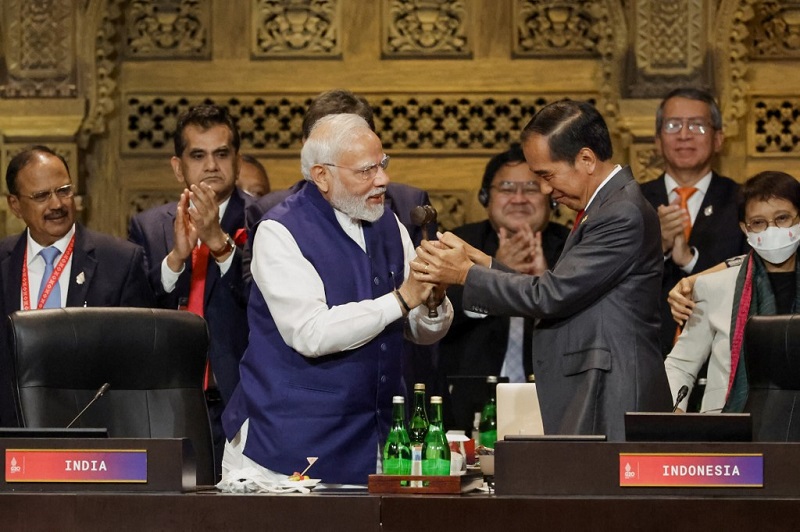 India's Prime Minister Narendra Modi (L) and Indonesia's President Joko Widodo take part in the handover ceremony during the G20 Summit in Nusa Dua on the Indonesian resort island of Bali on November 16, 2022. (Photo by WILLY KURNIAWAN / POOL / AFP)