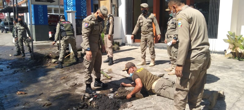 Petugas Satpol PP Garut Bantu Bersihkan Selokan di Jalan Otista