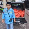 Kepala Desa Sukasenang, Kec. Banyuresmi Iwan Ridwan sedang memperlihatkan bantuan dari Dinas Sosial.