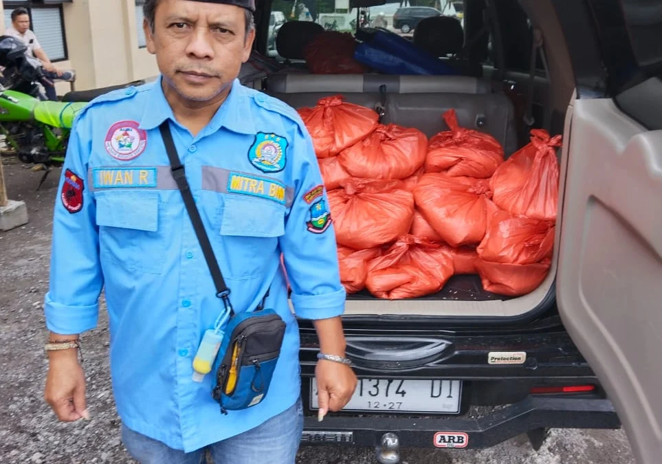 Kepala Desa Sukasenang, Kec. Banyuresmi Iwan Ridwan sedang memperlihatkan bantuan dari Dinas Sosial.