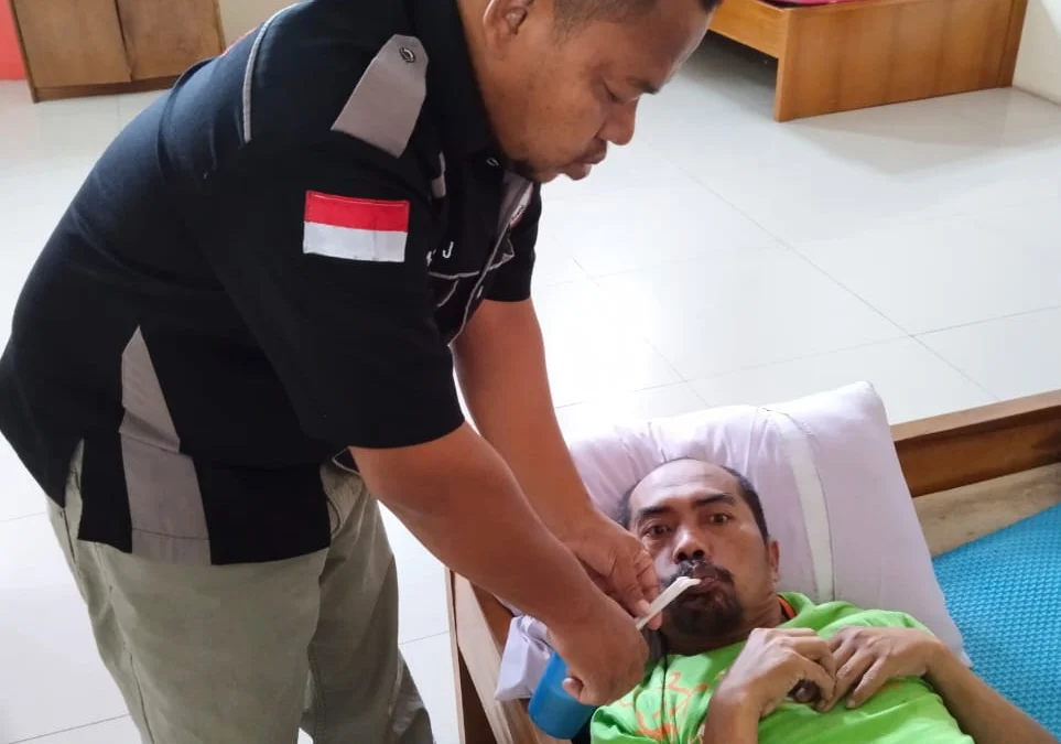 Petugas Tim Respon Sosial (TRS) Dinsos Garut, Asep Jaelani sedang memberikan makanan.