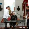 Presiden Jokowi membetulkan mikrofon ketika Putri Ariani akan membawakan lagu di Istana Merdeka