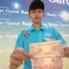 Soni Akbar, remaja asal Garut menunjukkan uang kertas kuno di kantor Radar Garut