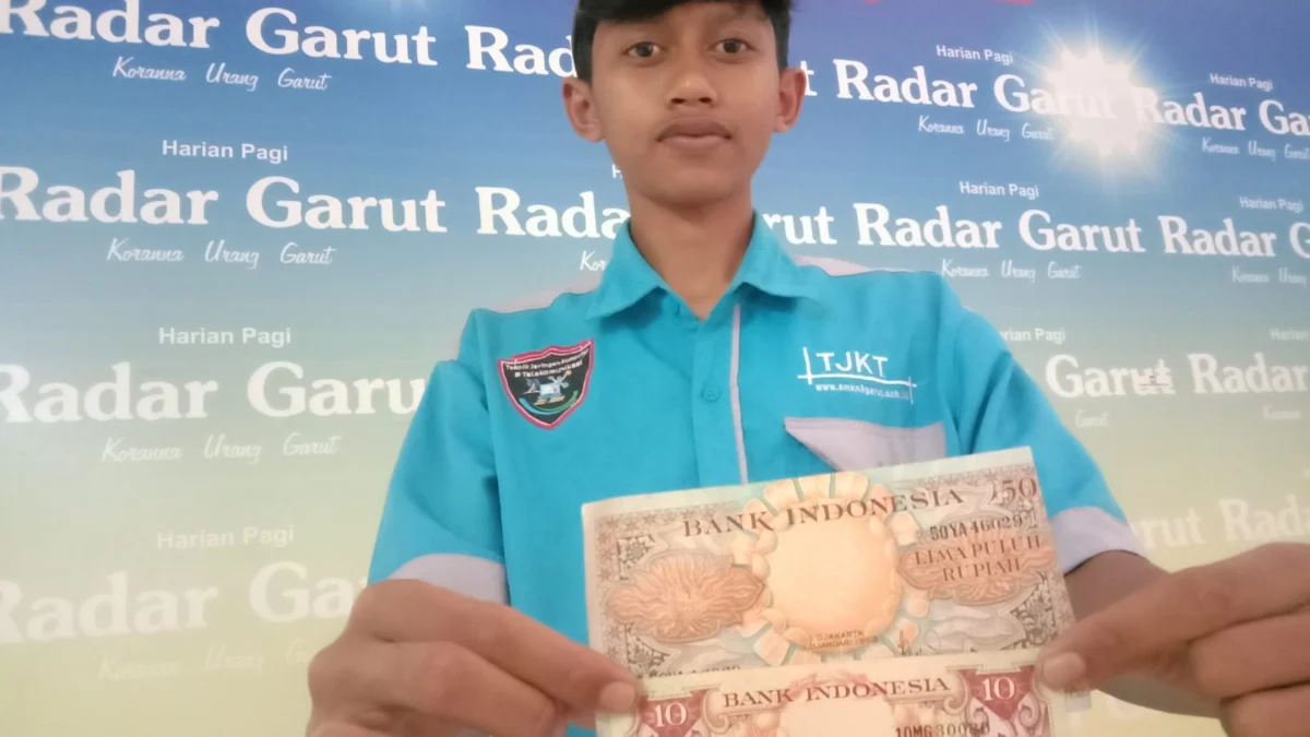 Soni Akbar, remaja asal Garut menunjukkan uang kertas kuno di kantor Radar Garut