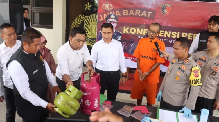 Kapolres Sumedang, AKBP Joko Dwi Harsono, menyaksikan cara tersangka mengoplos gas elpiji yang diperagakan oleh jajaran Satreskrim di Mapolres Sumedang,