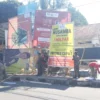 Petugas Satpol PP Garut saat menertibkan baligo bacalon bupati dan reklame yang terpasang percis dirembok SMPN