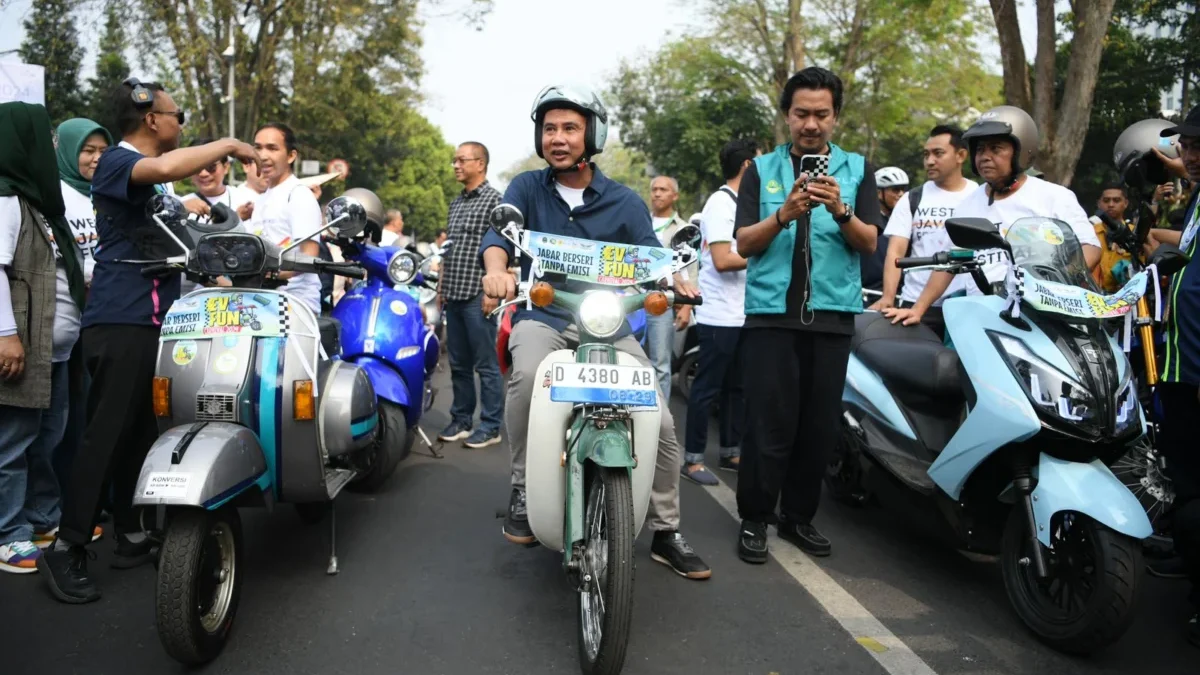 Penjabat Gubernur Bey Machmudin menaiki motor bekjul hijau yang telah dikonversi jadi kendaraan listrik saat k