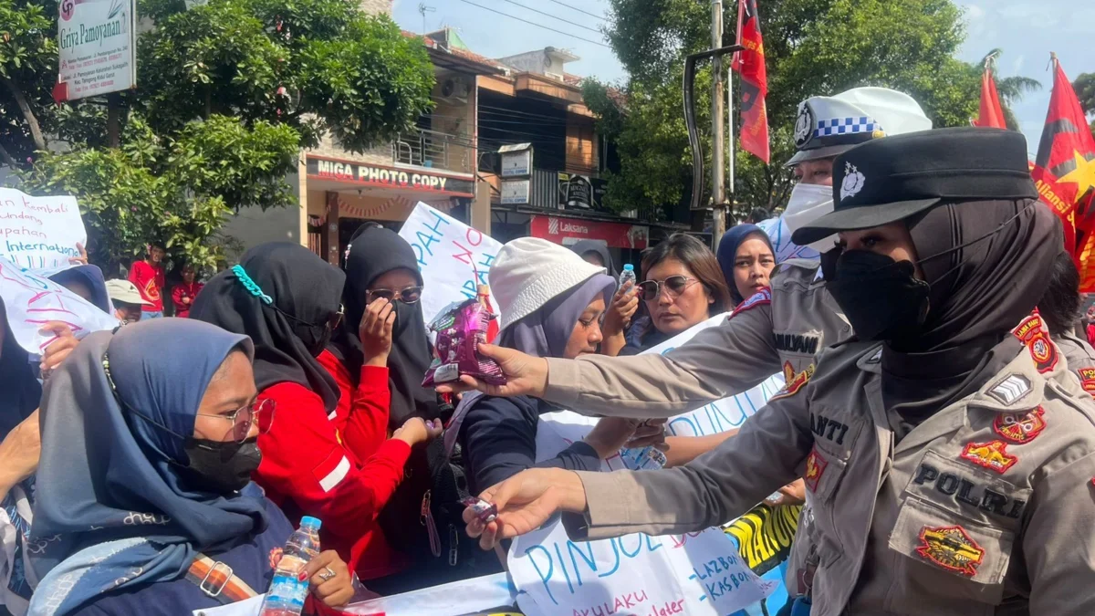 Polisi membagikan air minum dan permen di saat aksi unjuk rasa