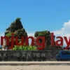 Sukabumi Ekspres - Pantai Tanjung Layar di Sukabumi, Jawa Barat merupakan salah satu tempat wisata yang terkenal dengan pesona alamnya yang menakjubkan. menyajikan di tepi pantai barat Jawa, Tanjung Layar memiliki keindahan alam yang sangat memukau dengan latar belakang laut yang biru dan tenang. Pesona alamnya terdiri dari tebing-tebing karang yang melonjak tinggi dan ombak yang bergerak dengan lembut, yang menambah keindahan panorama. Baca Juga: Wisata Pantai Sawarna Sukabumi Jawa Barat Tanjung Layar juga menjadi tempat yang ideal untuk melakukan berbagai aktivitas, seperti berenang, snorkeling, dan selancar. Tempat surfing di Tanjung Layar memiliki ombak yang cukup besar sehingga menjadi surga bagi para peselancar yang ingin mencoba tantangan di laut. Wisatawan juga bisa menikmati keindahan laut di sekitar Tanjung Layar dengan melakukan snorkeling atau menyewa perahu nelayan. Berikut ini merupakan informasi tentang harga tiket masuk, lokasi, dan destinasi wisata di Tanjung Layar Sukabumi Harga Tiket Masuk Harga tiket masuk ke Pantai Tanjung Layar sangat terjangkau, yaitu Rp5000 per orang. Biaya tersebut sudah mencakup biaya masuk ke pantai lain seperti Pantai Ciantir dan Pantai Gua Langir. Namun, tiket tersebut hanya berlaku untuk masuk ke pantai saja dan tidak termasuk biaya untuk peralatan aktivitas seperti tikar, makanan dan minuman, pelampung, dan lainnya. Baca Juga: Destinasi Wisata Murah di Pangalengan, Cocok untuk Libur Lebaran! Penting untuk dicatat bahwa kendaraan roda empat tidak dapat melewati Pantai Tanjung Layar. Oleh karena itu, pengunjung harus memarkir mobil mereka sebelum gantung jembatan masuk wisata. Biaya parkir tergantung pada durasi kunjungan, dengan biaya parkir sekitar Rp20.000 hingga Rp25.000 jika menginap, dan biaya parkir Rp5.000 jika hanya berkunjung sebentar. Lokasi Tanjung Layar Sukabumi Pantai Tanjung Layar dapat ditempuh dari Jakarta dalam waktu sekitar 5,5 jam melalui tol Jakarta Merak, lalu keluar ke arah Sukabumi dan ambil jalur menuju desa Sawarna. Selain itu, Anda juga bisa mencapai Pantai Tanjung Layar melalui jalur Cijeruk dan Cibadak yang kemudian bertemu di Pelabuhanratu dan ambil arah Cisolok untuk menuju desa Sawarna. Daya Tarik Tanjung Layar Sukabumi Ketika berkunjung ke Pantai Tanjung Layar, terdapat beberapa aktivitas yang bisa dilakukan seperti berenang, bermain pasir, berselancar, berfoto di karang, berkemah, dan melihat matahari terbit. Namun, tetap perlu berhati-hati saat melakukan aktivitas dan patuhi aturan yang ada. Baca Juga: Deretan Wisata Murah di Sukabumi, Ada yang Gratis Loh! Untuk penginapan, terdapat beberapa pilihan yang terletak tidak jauh dari Pantai Tanjung Layar, dengan jarak sekitar 400-500 meter yang bisa diakses dengan berjalan kaki atau menggunakan kendaraan motor. Salah satu pilihan yang menarik adalah Bimbim Homestay yang lokasinya menghadap langsung ke laut dan memiliki pemandangan yang indah, sehingga menjadi pilihan tepat bagi pengunjung yang ingin menikmati pemandangan laut dan mudah mengakses pantai. Pantai Tanjung Layar di Sukabumi merupakan tempat wisata pantai yang menarik untuk dikunjungi. Dengan biaya tiket masuk yang murah, pengunjung bisa menikmati berbagai aktivitas seperti berenang, bermain pasir, selancar, berfoto di karang, berkemah, atau sekadar menikmati sunrise. Pantai ini juga memiliki beberapa penginapan yang nyaman untuk menginap selama berlibur. Meskipun tidak bisa dilalui kendaraan roda empat, namun perjalanan ke pantai ini cukup mudah dan bisa ditempuh dari Jakarta kurang lebih 5,5 jam. Bagi Anda yang ingin mengunjungi pantai dengan suasana yang masih alami dan tidak terlalu ramai, Pantai Tanjung Layar adalah pilihan yang tepat. Baca Juga: 5 Hotel Terbaik di Pelabuhan Ratu Sukabumi