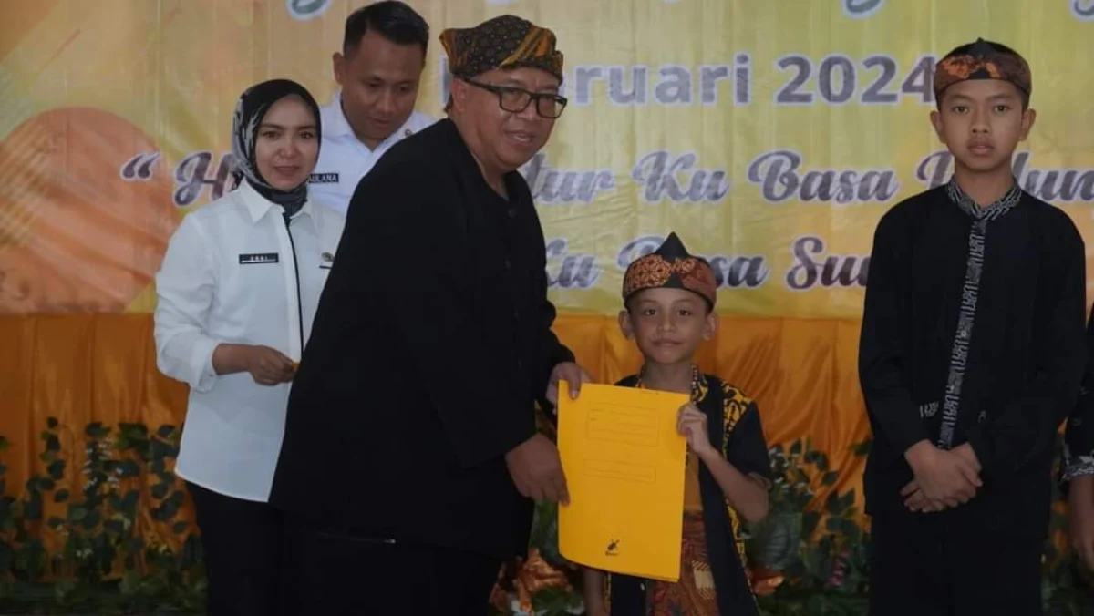 Bupati Sukabumi, Marwan Hamami saat memberikan penghargaan kepada salah satu siswa berprestasi.