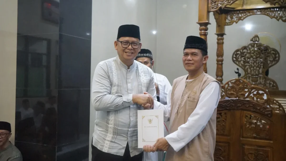 Pj Wali Kota Sukabumi Kusmana Hartadji (kiri) menyerahkan bantuan kepada DKM Al-Muhajirin.