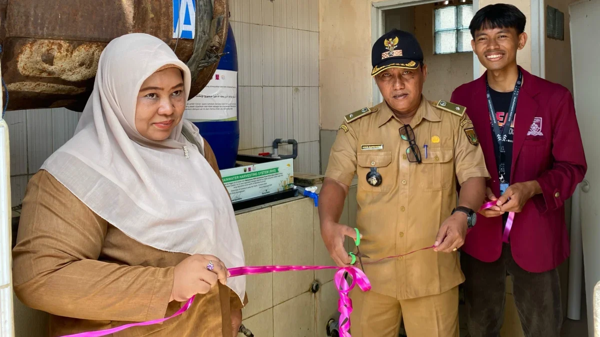 Kepala Desa Karangpapak Agus Supriatna (tengah) menggunting pita