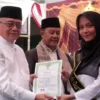 Wakil Bupati Sukabumi, Iyos Somantri saat menyerahan ijazah kepara salah satu peserta wisuda