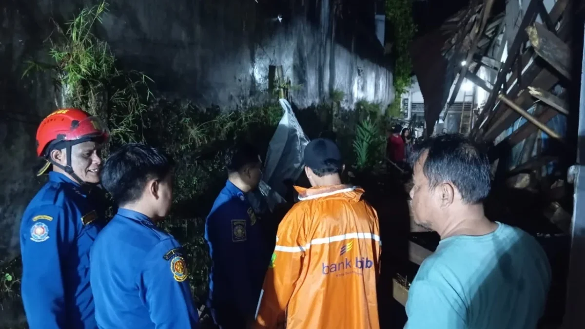 Petugas BPBD dibantu unsur lainnya mengevakuasi salah satu bangunan rumah
