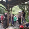 Petugas Kepolisian saat mengevakuasi Korban yang tersambar petir di sebuah warung.