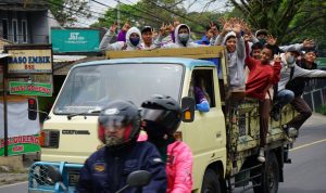 Sejumlah anak sekolah menghadang truk yang sedang melaju di ruas Jalan Raya Bandung Sumedang, tepatnya di Kecamatan Cimalaka.