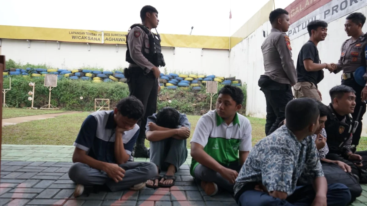 anggota polisi memberikan nasehat kepada seorang siswa yang menangis saat diamankan pihak kepolisian