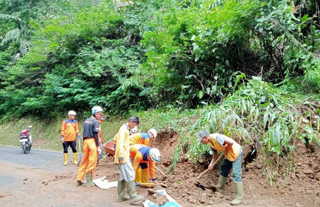 KONDISI JALAN: BPBD membersihkan jalan yang tertutup tanah longsor.