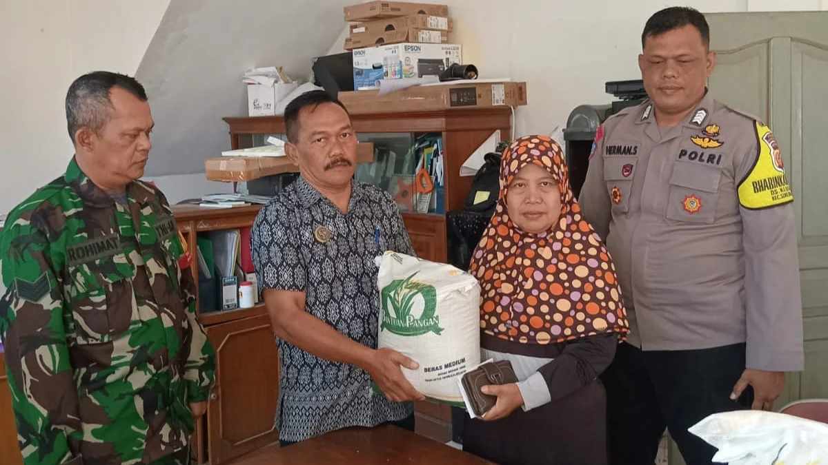 SIMBOLIS: Didampingi Babinkantibmas dan Babinsa Kepala Desa Kebonjati, Jajang memberikan simbolis bantuan pangan kepada salah seorang warganya, Kamis (25/5).