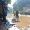 Beberapa Warga Ikut Membantu Petugas Membawa Mayat yang Ditemukan Warga di Sungai Cipeles