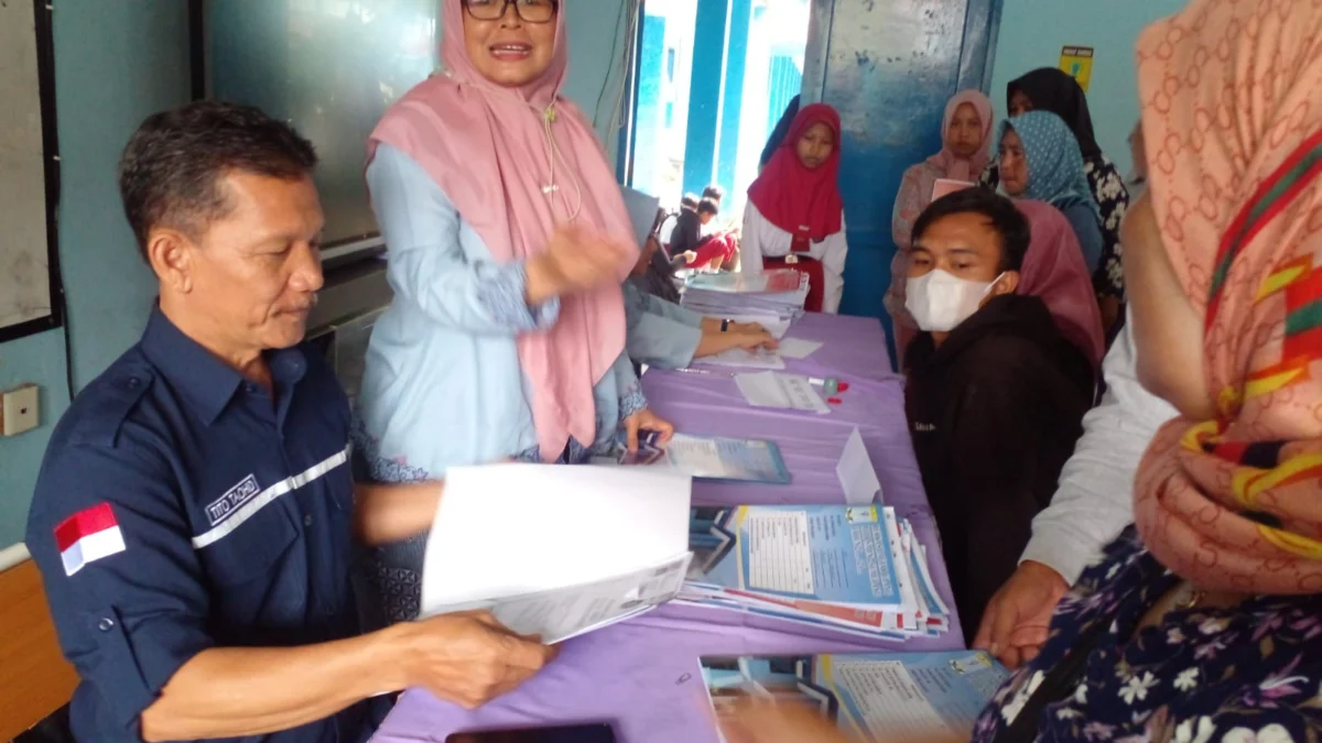 RAMAI: Wakasek SMPN 2 Sumedang Tito Taohid SPd (kiri), pada kegiatan daftar ulang di SMPN 2 Sumedang beberapa waktu yang lalu.