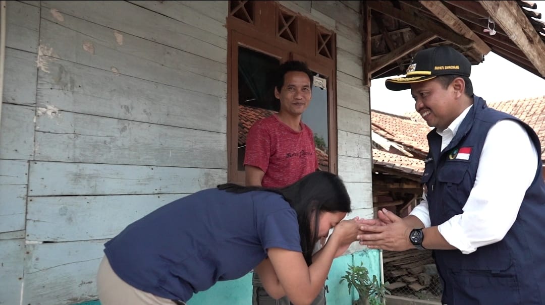 BERSALAMAN: Bupati Sumedang H Dony Ahmad Munir didampingi Ketua TPKK Kabupaten Sumedang Hj Susi Gantini bersalaman ke salah satu warga Desa Cipeles, Kecamatan Tomo, baru-baru ini.(istimewa)