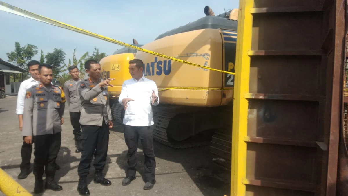 TINJAU ALAT BERAT: Kabid Humas Polda Jabar Kombespol Ibrahim Tompo (tengah) melakukan peninjauan tiga unit akscavator dan ayakan pasir, yang dijadikan barang bukti dua tersangka penambangan ilegal, di Mapolres Sumedang, kemarin. (FOTO: ASEP NURDIN)