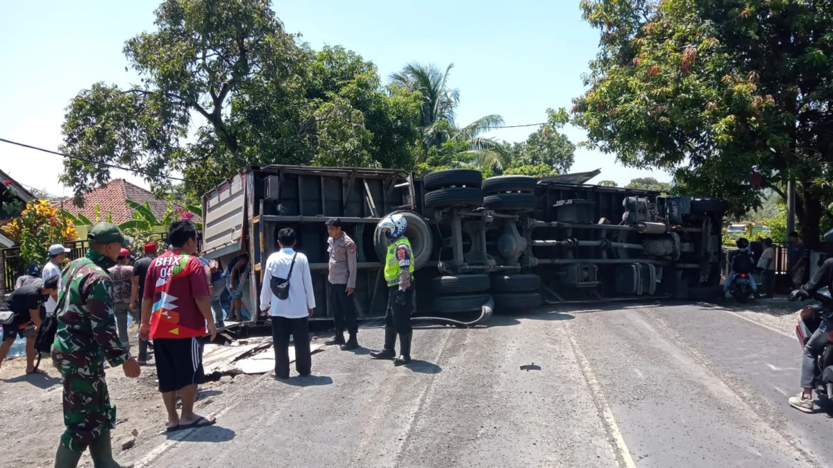 EVAKUASI: Anggota Satlantas Polres Sumedang dibantu warga melakukan evakuasi Truk Box yang terguling, di Tanjakan Nyalindung, Dusun Warung Buah, Desa Padanaan, Kecamatan Paseh, Rabu (13/9).(istimewa)