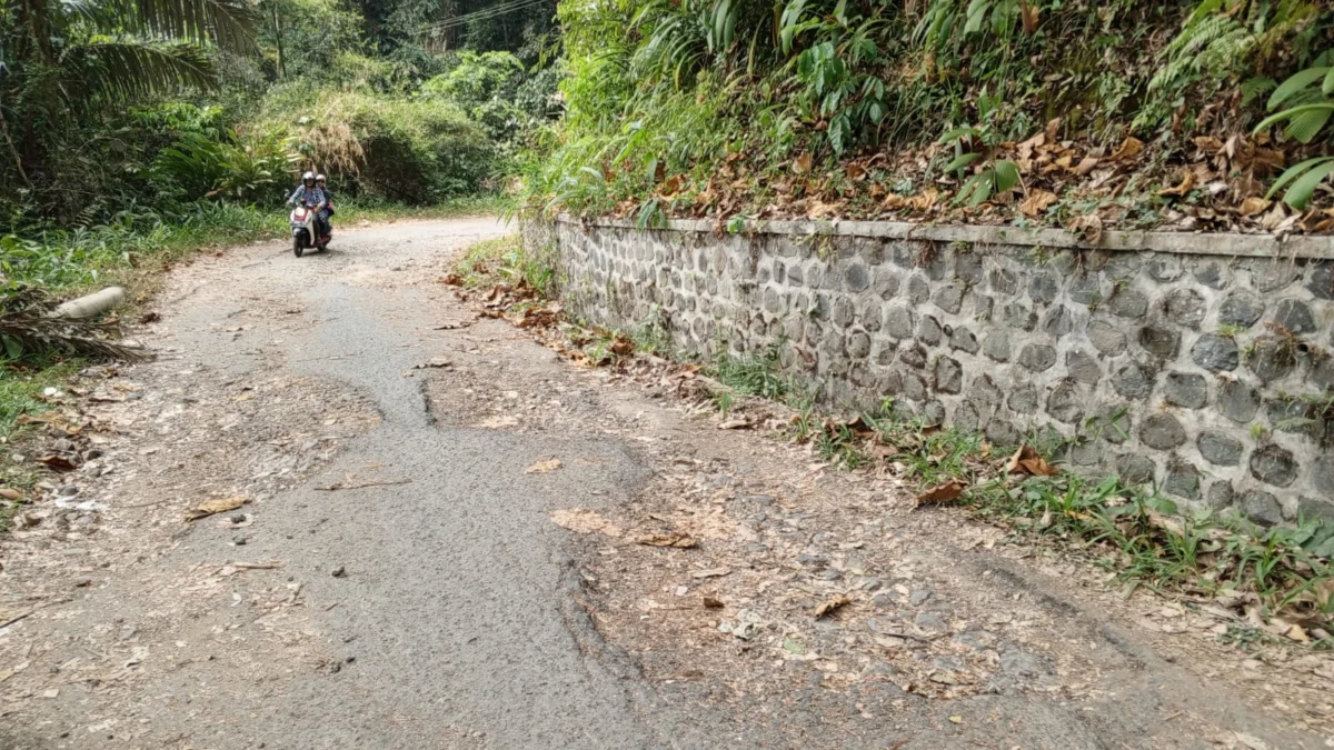 BERLUBANG: Pemotor melintasi jalan rusak dengan was-was di Jalan Pager Betis, Desa Citengah, Kecamatan Sumedang Selatan, KM 9, baru-baru ini.(foto Rizki)