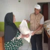 SIMBOLIS: Lurah Situ saat memberikan bantuan beras 10 Kg, kepada salah seorang warganya, yang bersumber dari bantuan Badan Ketahanan Pangan Nasional dan Bulog, di Desa Situ, baru-baru ini. Istimewa