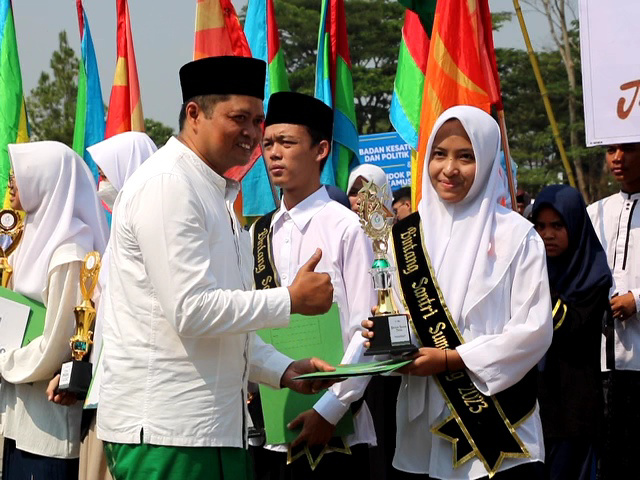 APRESIASI: WAKIL Ketua DPRD Sumedang H. Ilmawan Muhamad, S.Ag., M.M., menyerahkan penghargaan kepada Bintang Santri Sumedang 2023 pada Peringatan Hari Santri Nasional 2023 di Lapang Upacara Pusat Pemerintahan Sumedang (PPS),