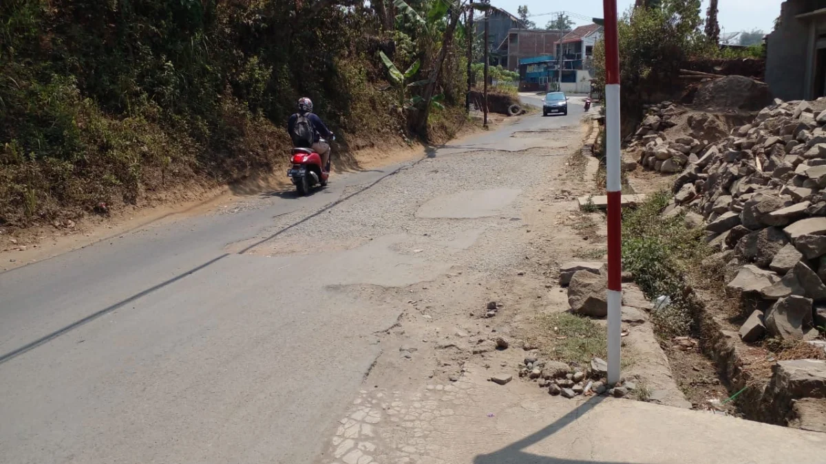 WASWAS: Tampak seorang pemotor sampai memilih bahu jalan untuk dilalui, karena kondisi jalan sangat rusak parah dan berlubang.