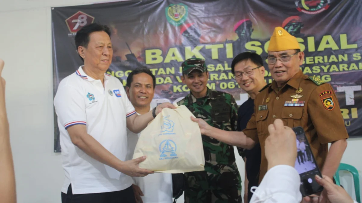 PEDULI: Sekretaris Ridwan Sopiana S.Pd saat menyerahkan beras bantuan pemerintah pusat kepada warga desanya, di Cimanggunh, kemarin.