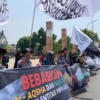 BERSUARA: Masa bergerak long mach  dari Mesjid Tegalkalong menuju Alun-alun Sumedang, dengan membawa spanduk, poster serta bendera aroyah dan al liwa, kemarin.