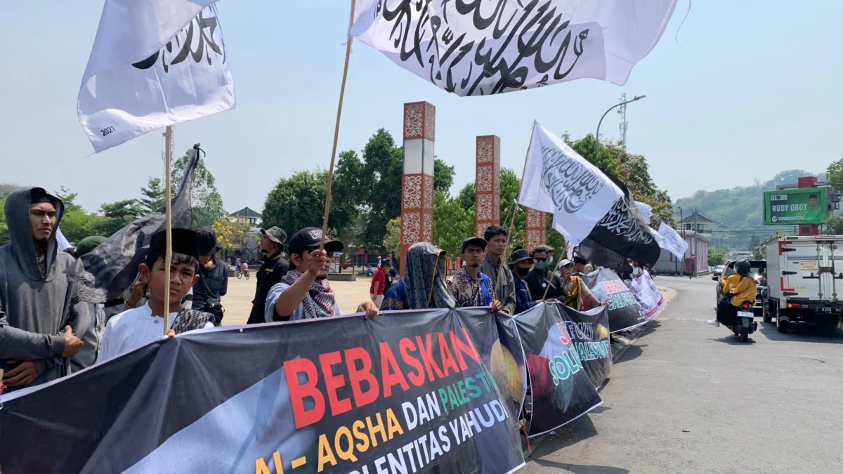 BERSUARA: Masa bergerak long mach  dari Mesjid Tegalkalong menuju Alun-alun Sumedang, dengan membawa spanduk, poster serta bendera aroyah dan al liwa, kemarin.