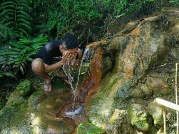 ISTIMEWA OBAT: Salah satu warga tengah menikmati mata air Ciuyah di Dusun Cimarga, Desa Karanglayung Kecamatan Conggeang, baru-baru ini.