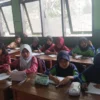 SEMANGAT: Siswa SDN Parakanmuncang 02 tengah mengikuti kegiatan belajar di kelas yang rusak, baru-baru ini.