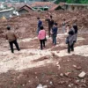 PENUH PILU: Pasaribu bersama korban longsor lainnya saat melihat lokasi pasca bencana longsor, yang menewaskan anak dan istrinya di Desa Cihanjuang Kecamatan Cimanggung, baru-baru inil