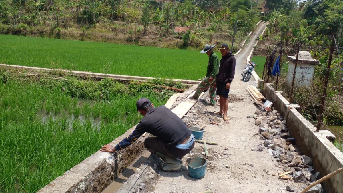 IKUT SERTA: Kadus 1 Desa Kebonjati Asep Arma (tengah), saat meminpin kegiatan perbaikan Jalan Usaha Tani (JUT) dan pembangunan TPT di Dusun Cipulus, baru-baru ini.