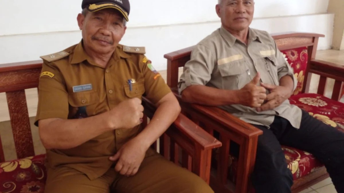 BERI KETERANGAN: Kepala Desa Cimalaka Dadang Suryana saat bersama Angota BPD Desa Cimalaka, Drs Dedi Junaedi di kantornya, baru-baru ini