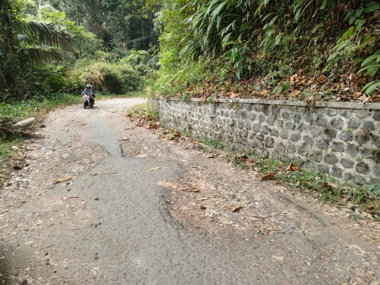 WASWAS: Pemotor tengah melintasi jalan yang rusak dan berlubang di salah satu daerah di Sumedang, baru-baru ini.